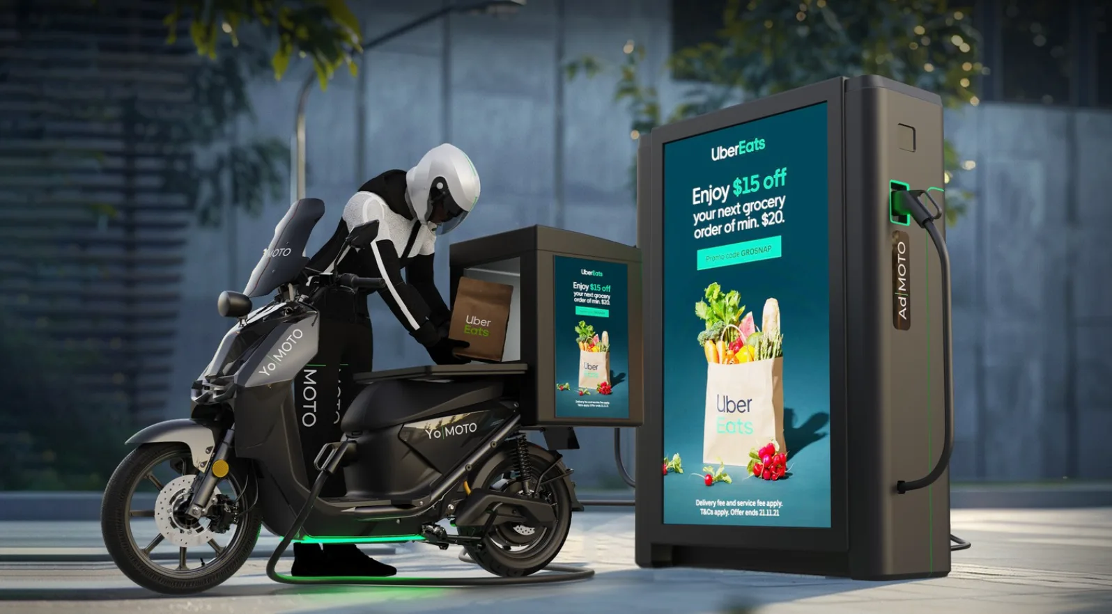 Ad|MOTO rider at a scooter beside an Ad|MOTO charging tower with a large ad screen